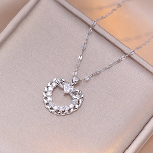 Détail d'un collier pendentif cœur argenté avec strass dans un coffret à bijoux de luxe