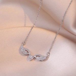 Elegant angel wings heart necklace with white zircon on champagne silk background