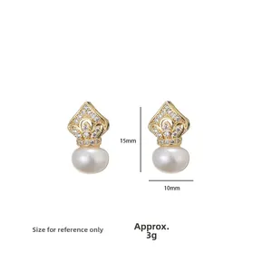 Detail of elegant gold crown earrings with sparkling zircons and large white pearls