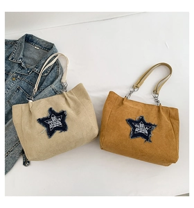 Detail of suede tote bags featuring star denim patches and metal chain handles