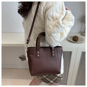 Grand sac cabas en cuir PU marron porté à l'épaule dans un intérieur chaleureux