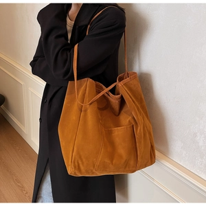 Detail of tan suede tote bag featuring high-quality texture and minimalist outer pocket