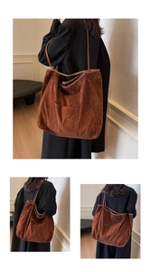 Macro details of a large brown suede tote bag with front pocket and shoulder strap