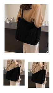 Close-up of black corduroy tote bag featuring a practical front pocket and ribbed texture