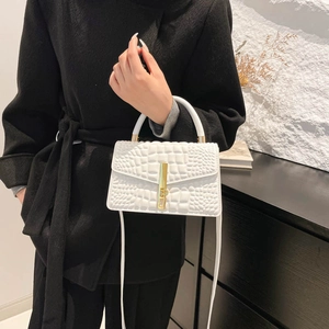 Elegant white crocodile embossed crossbody bag with gold buckle on a model