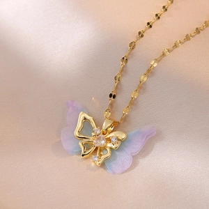 Makro-Detail einer doppellagigen lila Schmetterlingskette mit goldener Wellenkette