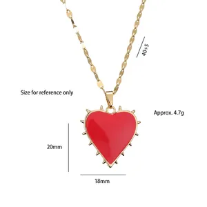 Gothic red heart pendant necklace with gold spikes and fine chain on white background