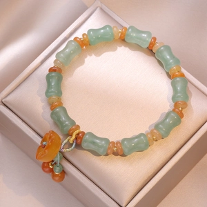 Bracelet en perles de jade aventurine verte avec pendentif fleur sur coffret soie