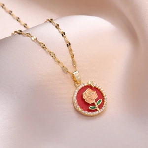 Elegant gold necklace with rose pendant and zircon frame on soft pink satin fabric