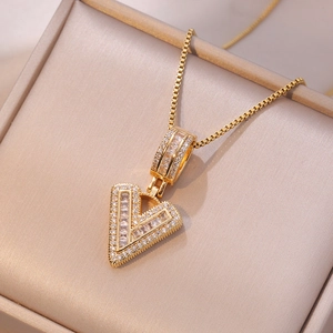 Elegant gold-tone V-letter pendant necklace with baguette and round-cut zirconia stones
