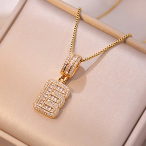 Macro detail of gold letter E pendant with cubic zirconia on a box chain