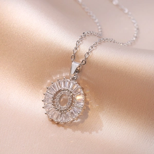 Macro detail of silver O-letter pendant necklace with shimmering baguette-cut crystals