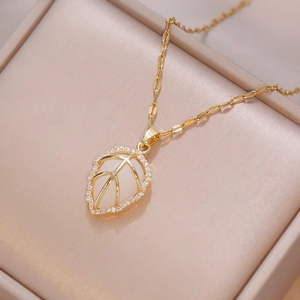 Golden leaf necklace with white opal-effect stone and sparkling zircon halo in a gift box