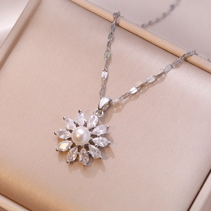 Silver sunflower necklace with white pearl and marquise cubic zirconia on champagne background