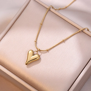 Collier élégant avec pendentif coeur doré et chaîne perlée sur boîte à bijoux