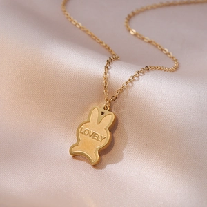 Golden titanium steel necklace with a lovely rabbit pendant on soft pink silk background