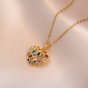 Pendentif cœur doré avec pierres en zircone colorées sur un élégant tissu en soie