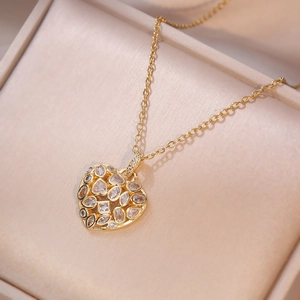 Collier en forme de cœur doré avec zircons étincelants dans son coffret à bijoux chic