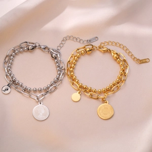 Bracelet double rang en acier inoxydable avec perles or et argent sur fond en soie