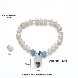 Detailed view of 8mm freshwater pearl bracelet with lily of the valley charm and blue accents