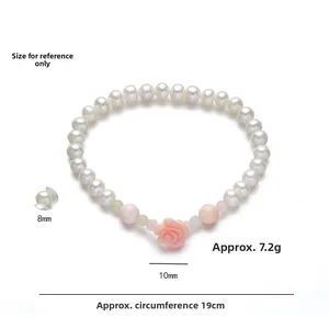 Detail view of 8mm freshwater pearl bracelet with a 10mm pink rose flower charm accessory