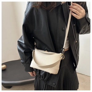 Detail of off-white lychee grain leather crossbody bag with elegant gold metal clasp
