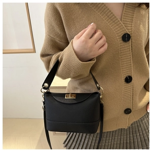Detail of black lychee grain leather bag with elegant gold metal twist lock buckle