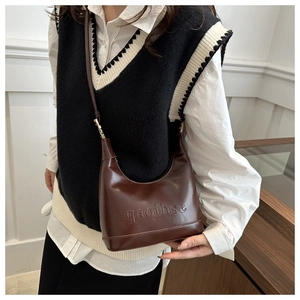 Detailed close-up of brown vintage underarm bag with embossed minimalist branding