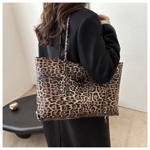 Detailed back view of a person wearing a leopard print tote bag with long shoulder straps