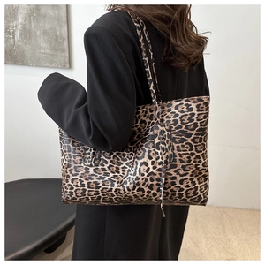 Detailed side view of large leopard print tote bag styled with a black suit for daily commute