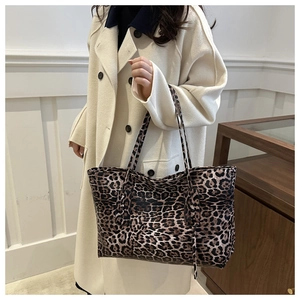 Detail of large leopard print tote bag with double leather handles and glossy finish