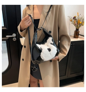 Detail of black PU leather shoulder bag featuring a cute white plush dog design on front