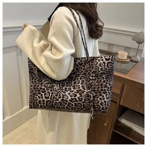 Side view of large leopard print tote bag styled in a cozy minimalist interior setting
