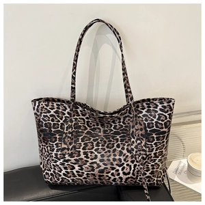 Close-up of leopard print tote bag texture and long shoulder strap on a modern background