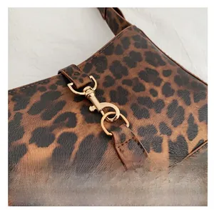 Gros plan détaillé d'un sac à bandoulière léopard avec fermoir mousqueton doré chic