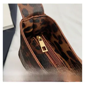 Gros plan sur la fermeture éclair en métal doré lisse d'un sac chic à motif léopard