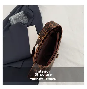 Détail montrant la poche intérieure zippée et le motif léopard du sac à main chic