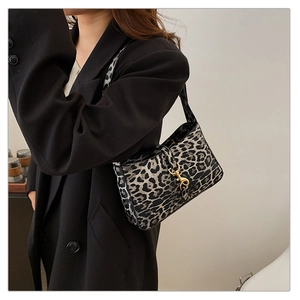 Détail du sac sous le bras imprimé léopard avec boucle dorée et style vintage chic