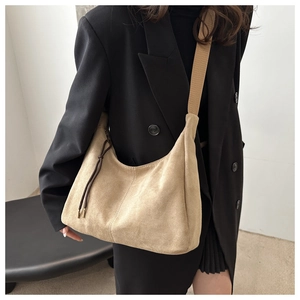 Detail view of khaki faux suede crescent crossbody bag with decorative side drawstrings
