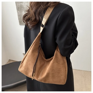 Detail view of large brown suede hobo bag with white stitching and adjustable strap