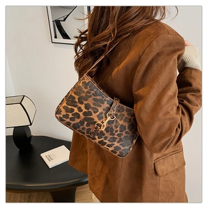 Vue détaillée d'un grand sac bandoulière léopard avec boucle dorée sur un mannequin