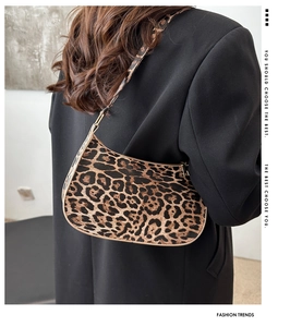 Detail of leopard print shoulder bag with textured fabric and sleek zipper closure