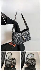 Détail du sac léopard avec boucle en métal doré et bandoulière en cuir réglable