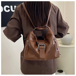 Détail du sac à dos vintage marron montrant le cuir souple et les fermetures éclair