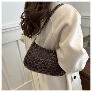Detail view of stylish leopard print shoulder bag worn with an elegant beige wool coat