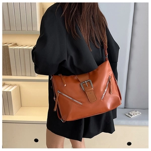 Détail du sac cabas en similicuir orange-brun avec boucle élégante et fermetures éclair