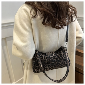 Detail of trendy leopard print shoulder bag worn with a white wool coat in a street style
