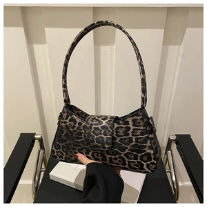 Detail of trendy leopard print baguette bag on a chair with stylish shoulder strap