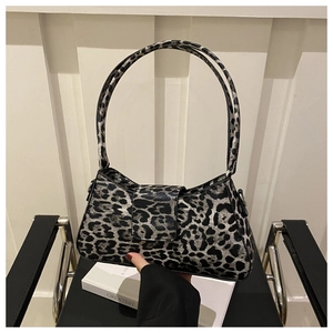 Top-down view of grey leopard print faux leather baguette bag on a black metal chair