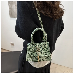 Detailed view of leopard print crossbody bag with S-shaped gold buckle on female model